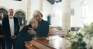 Senior women, hug and funeral in church for comfort, support and care with crying, sad and religion. Family, friends and embrace for death, loss and console with love, empathy and faith by coffin.
