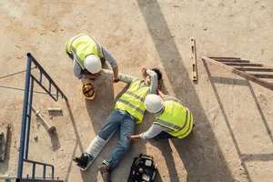 First aid worker accident in construction site, Builder accident fall scaffolding to concrete floor, Safety team help employee arm and leg injury from accident. Top view.